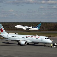 Deux avions d'Air Canada et de WestJet sur le tarmac.