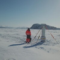 Un homme se tient debout devant un paysage arctique.