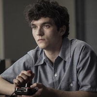 un jeune homme joue seul à un jeu vidéo avec une manette.