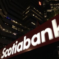 Logo de la Banque Scotia illuminé dans la nuit.