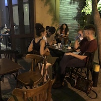 Cinq personnes assises à une table sur une terrasse.