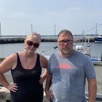 Un homme et une femme devant le quai de Lamèque, au Nouveau-Brunswick.