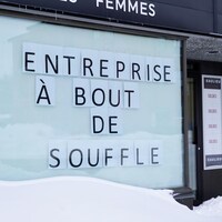 Devanture de commerce avec une affiche où il est inscrit "Entreprise à bout de souffle".
