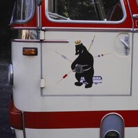 Un ours aux couleurs des divisions de la ville de Berlin sur un autocar qui circule dans la ville en 1965.