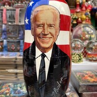 Le visage souriant de Joe Biden sur une poupée russe.