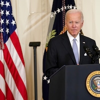 Joe Biden, derrière un lutrin à la Maison-Blanche et devant un drapeau américain.