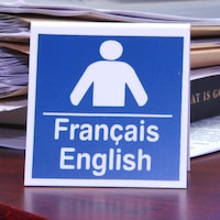 Affichette avec les mots « français » et « anglais » sur un comptoir.