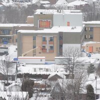 Un bâtiment de trois étages est en construction, en hiver.