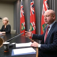 Lanette Siragusa et Brent Roussin assis à une table dans la salle de presse de l'assemblée législative.