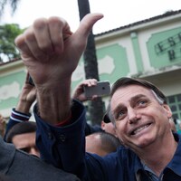 Dans la foule, Jair Bolsonaro lève son pouce en l'air en signe de victoire.