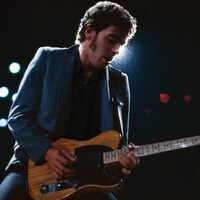 Un homme joue de la guitare sur scène. 