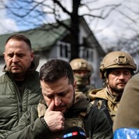 Entouré de soldats, le président ukrainien essuie une larme.