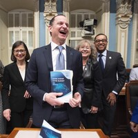 Eric Girard est tout sourire entouré d'autres élus de la CAQ.