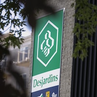 Deux enseignes montrant le logo de Desjardins sur la façade d'un édifice.