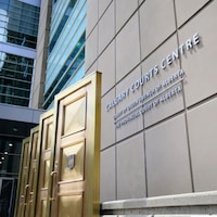 Trois portes en or à côté du signe du centre des cours de l'Alberta. 