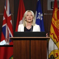 Candice Bergen parle devant des drapeaux des provinces canadiennes.