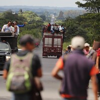 Des migrants latino-américains marchent le long d'une route.