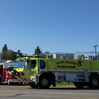 Deux camions de pompier devant une caserne.