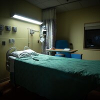 Un lit d'hôpital vide, la nuit.