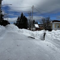 Un banc de neige bloque l'accès à une rue.
