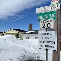 Un panneau inscrit chemin fermé en période hivernale.