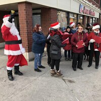 Une chorale ajoute de l'ambiance sur la rue Lafontaine à Rivière-du-Loup en compagnie d'un Père Noël.