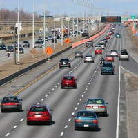 Des cônes orange bordent une autoroute. 