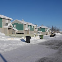 Plusieurs maisons semblables sur une rue enneigée de Matimekush-Lac John.