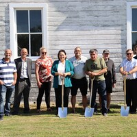 Une dizaine de personnes de la communauté tiennent des pelles pour la première pelletée de terre marquant le début des travaux du nouveau Musée de Saint-Laurent, le 7 septembre 2022.