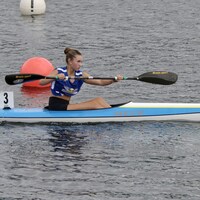 Une jeune fille pagaie en kayak.