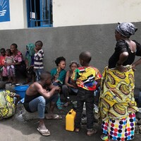 Des femmes et des enfants s'entassent près d'une église.