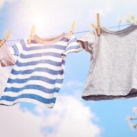 Des vêtements qui sèchent sur une corde à linge sous le soleil. 
