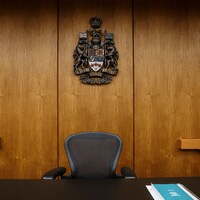 Chaise de juge surmontée des armoiries du Canada.
