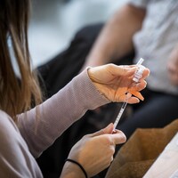 Une infirmière prépare une dose de vaccin.