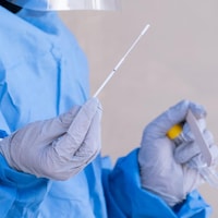 A person holding a COVID-19 swab test.