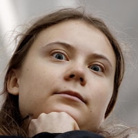 Greta Thunberg regarde la caméra avec des grands yeux très sérieux.