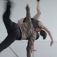 Deux danseurs effectuent une chorégraphie durant une répétition.