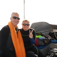 David et Denise Phelps en combinaisons de plongée, à bord d'un bateau.