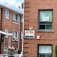 Des immeubles à logements abordables. Sur une fenêtre, on peut lire : « Je ne déménagerai pas. »