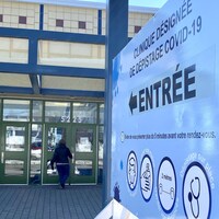 Une dame qui entre dans l'aréna avec la pancarte qui énonce les règles.