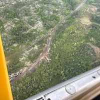 Une vue aérienne d'un déraillement de train au milieu d'une forêt au Manitoba.