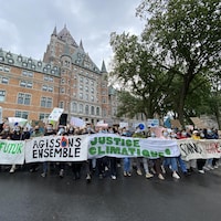 Le cortège de manifestants passe devant le château Frontenac.