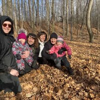 Une famille souriante dans le bois.