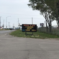 Un panneau en bordure de route sur lequel on peut lire : besoin de bras, 5 semaines, tirage 2000 $.