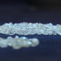 Deux amats de diamants sont exposés sous des lumières bleues.