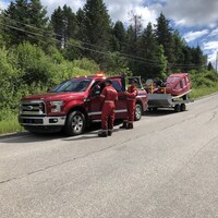 Une camionnette des pompiers transportant une remorque avec des équipements de recherche.