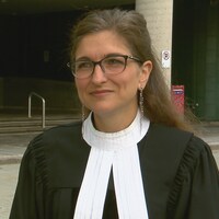 L'avocate porte sa toge devant le palais de justice de Québec.
