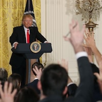 Des journalistes lèvent leurs mains pour poser des questions au président