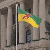 Un drapeau vert, jaune décoré par le ruban rouge, symbole de la lutte contre le sida, flotte devant le palais législatif de la Saskatchewan 