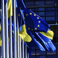 Des drapeaux de l'Union européenne et de l'Ukraine flottent au vent.